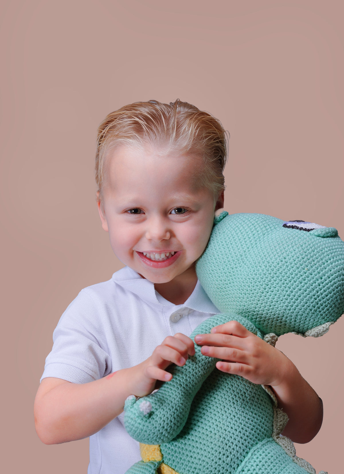 Close-up of a child's hands holding a knitted toy, school photography session in Dubai