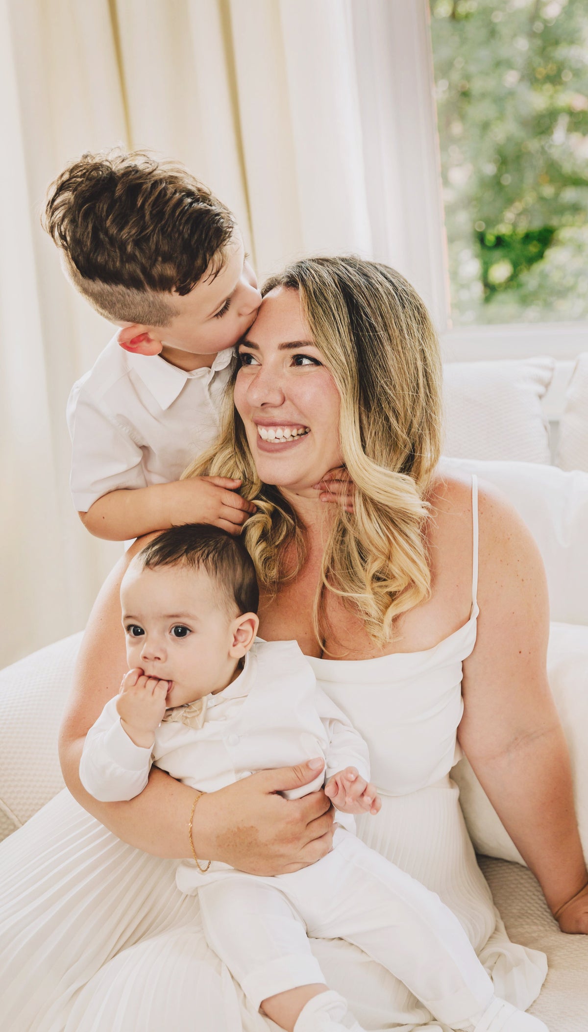 Mother laughing as her young son kisses her forehead, family photography session in Dubai