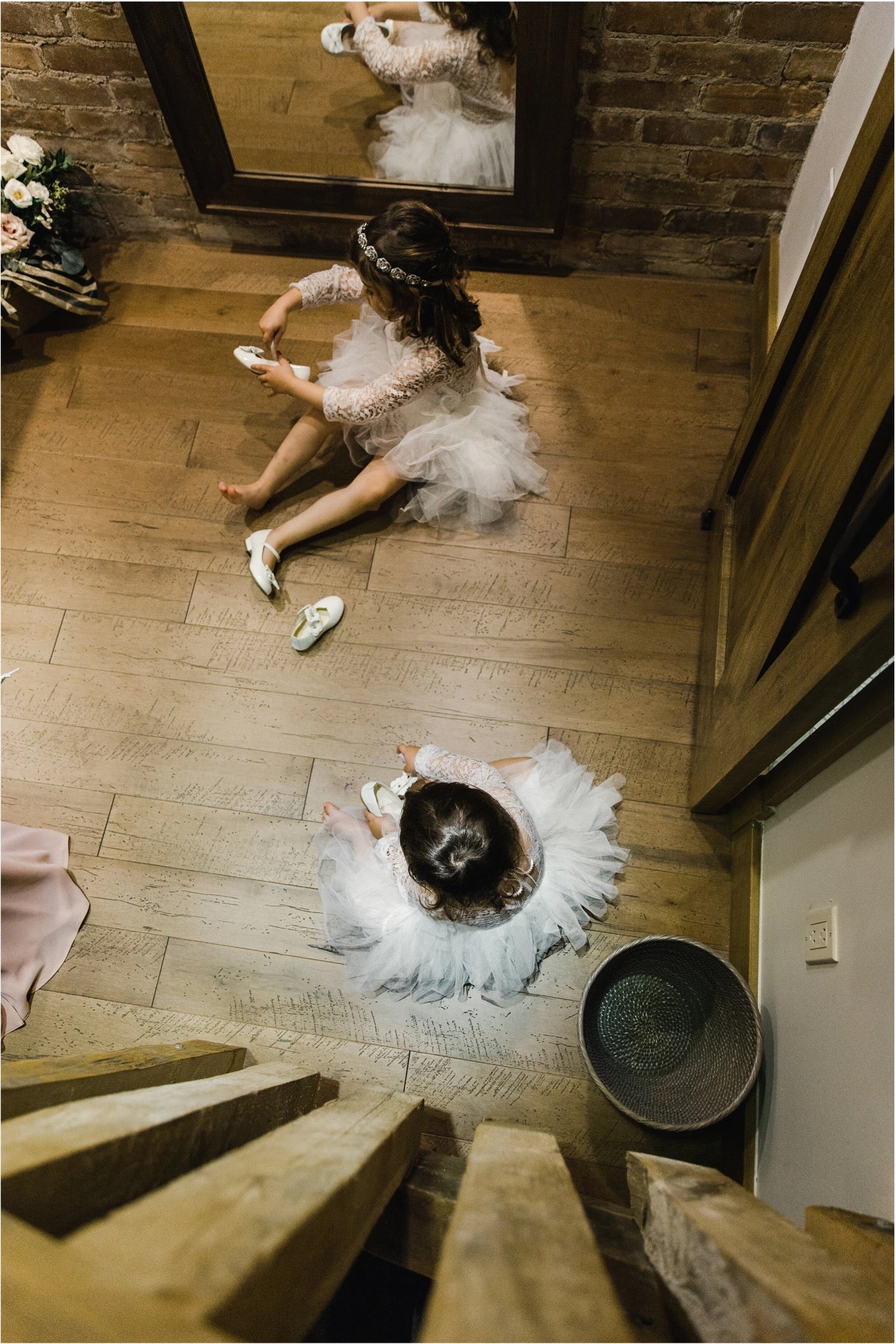 Flower girl in a tutu dress, seen from above on a wooden floor