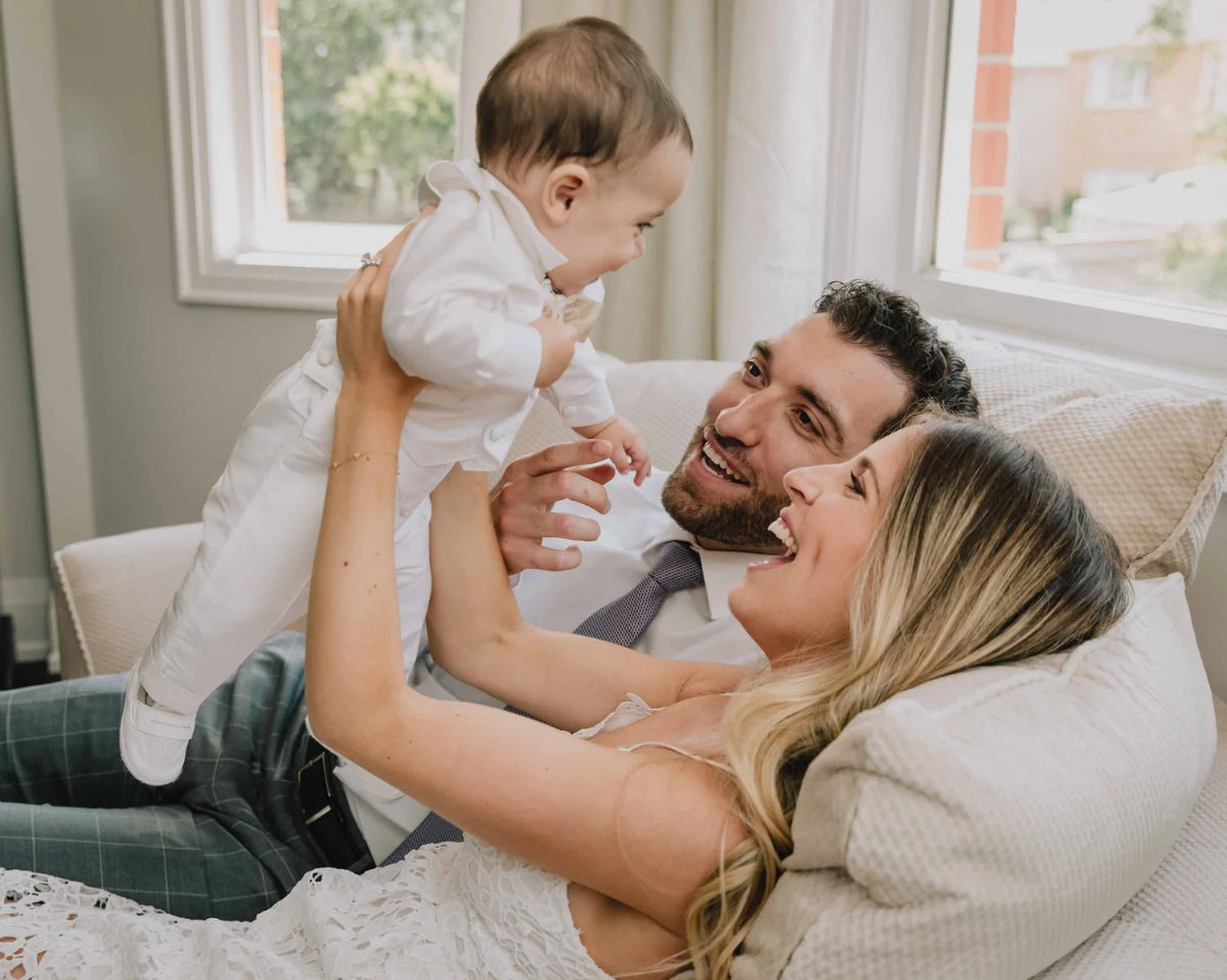 Couple with a baby on a couch in a cozy living room