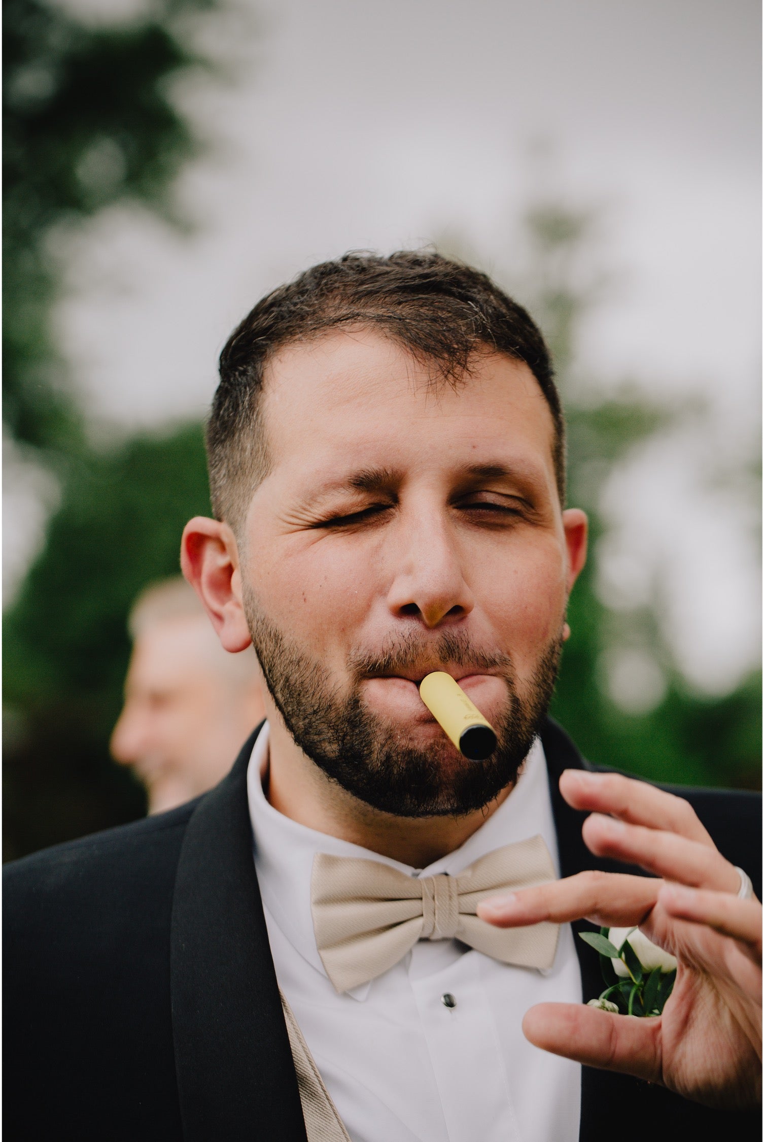 Candid moment of the groom smoking a cigar at the wedding reception